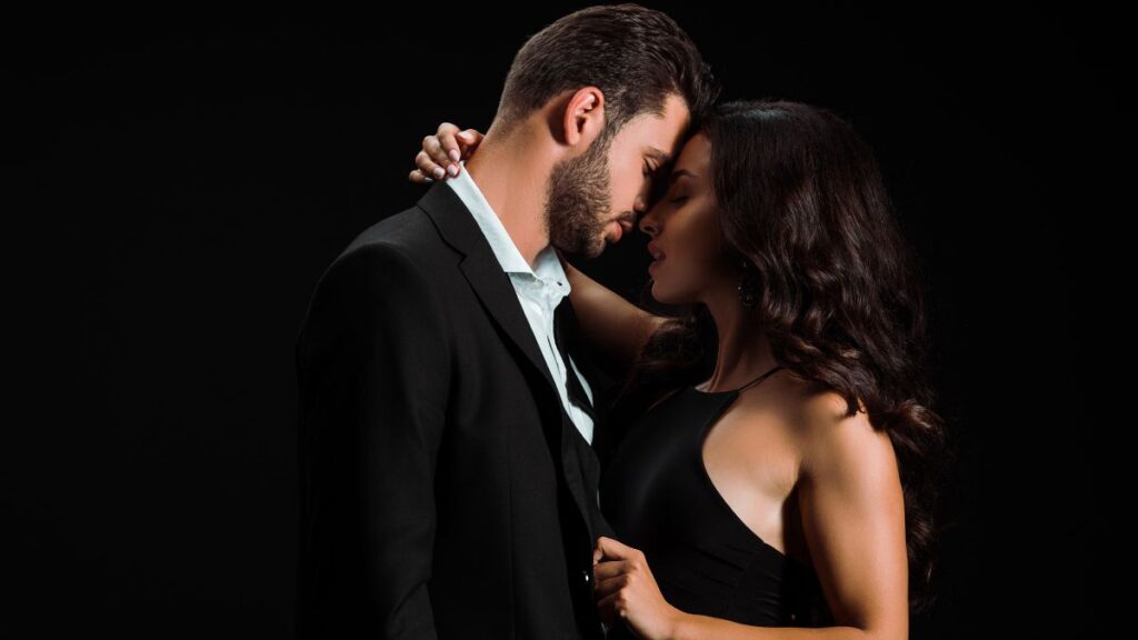 Man and Woman Kissing wearing a suite and black dress