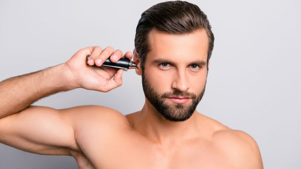 Ear hair trimming or removal man using an ear hair trimmer