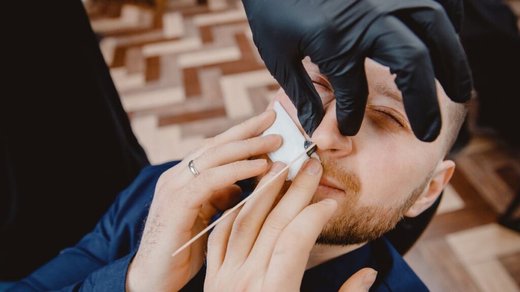 Nose hair trimming or removal man getting his nose waxed