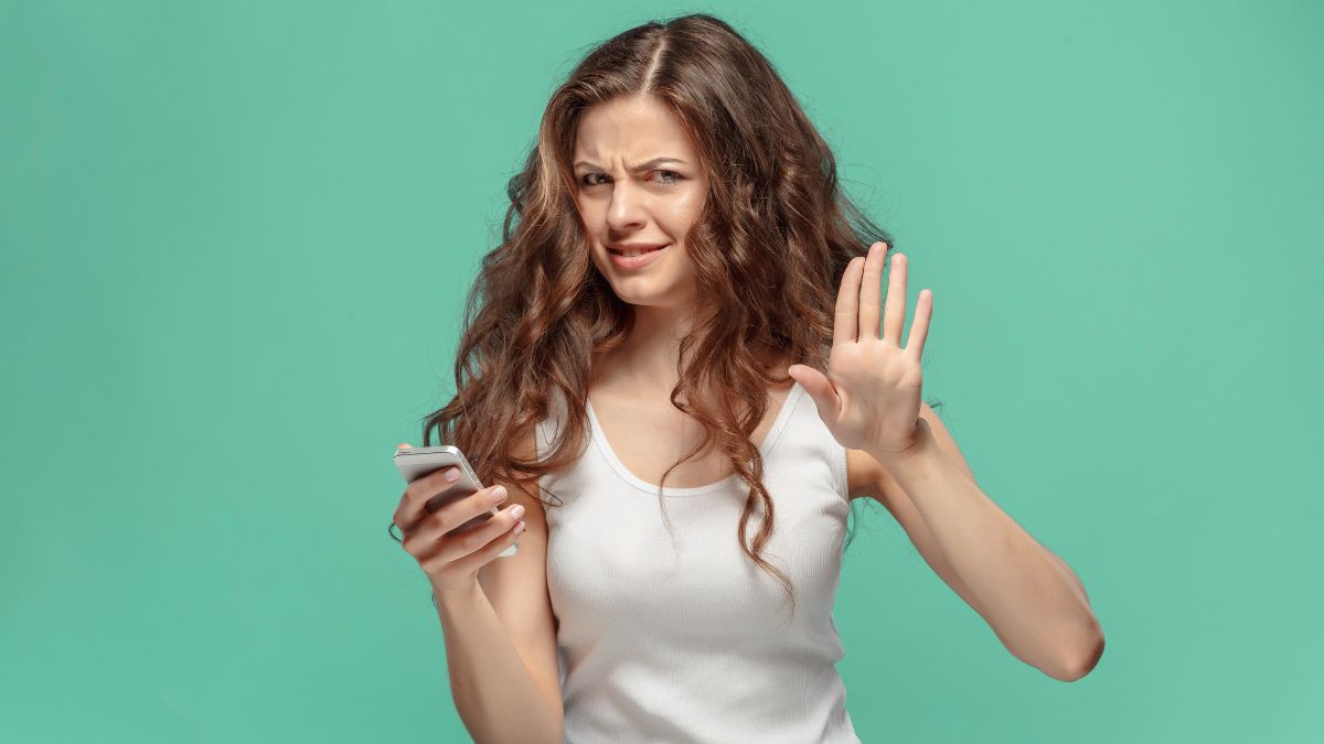 disgusted woman holding phone with hands up