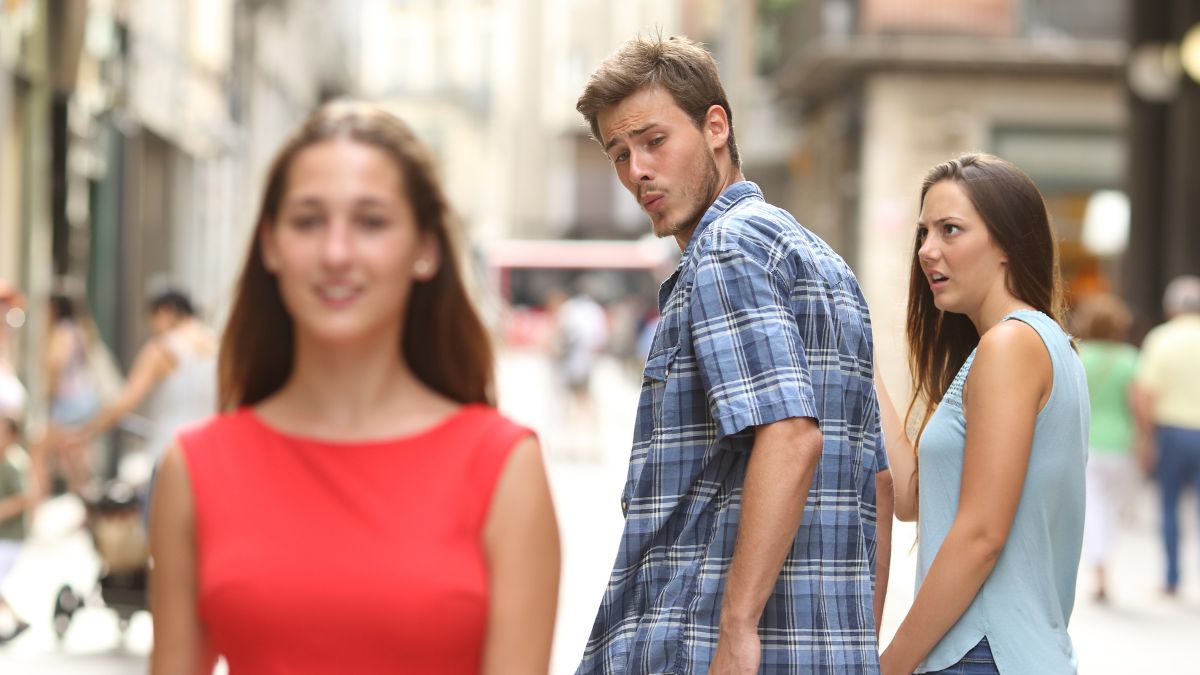 man looking at another woman in front of his girlfriend