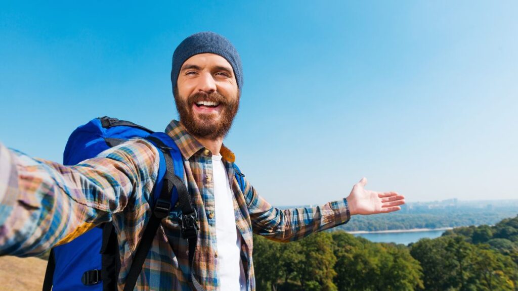 man standing happily on a hill