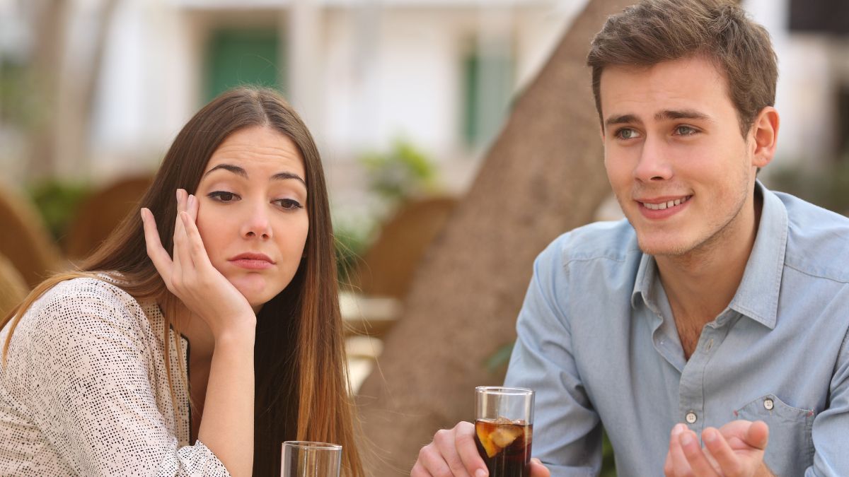 A woman looking bored on a date while the man talks