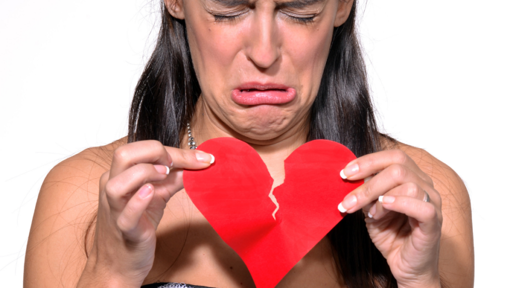 woman crying holding a broken heart