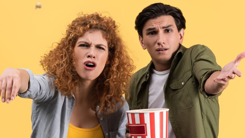 Man and Woman upset throwing popcorn