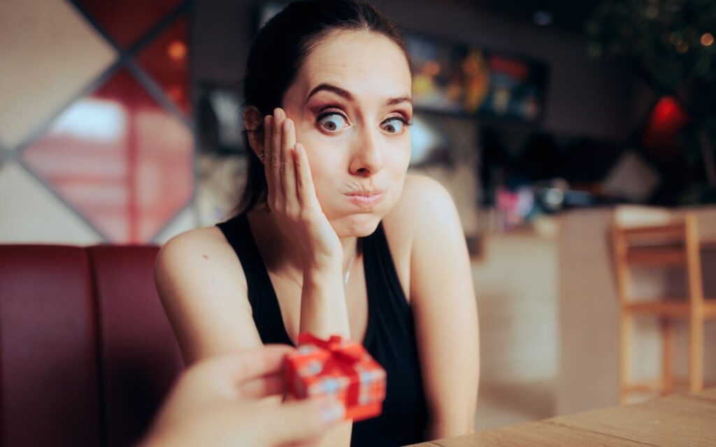 woman looking shocked and worried looking at a ring box